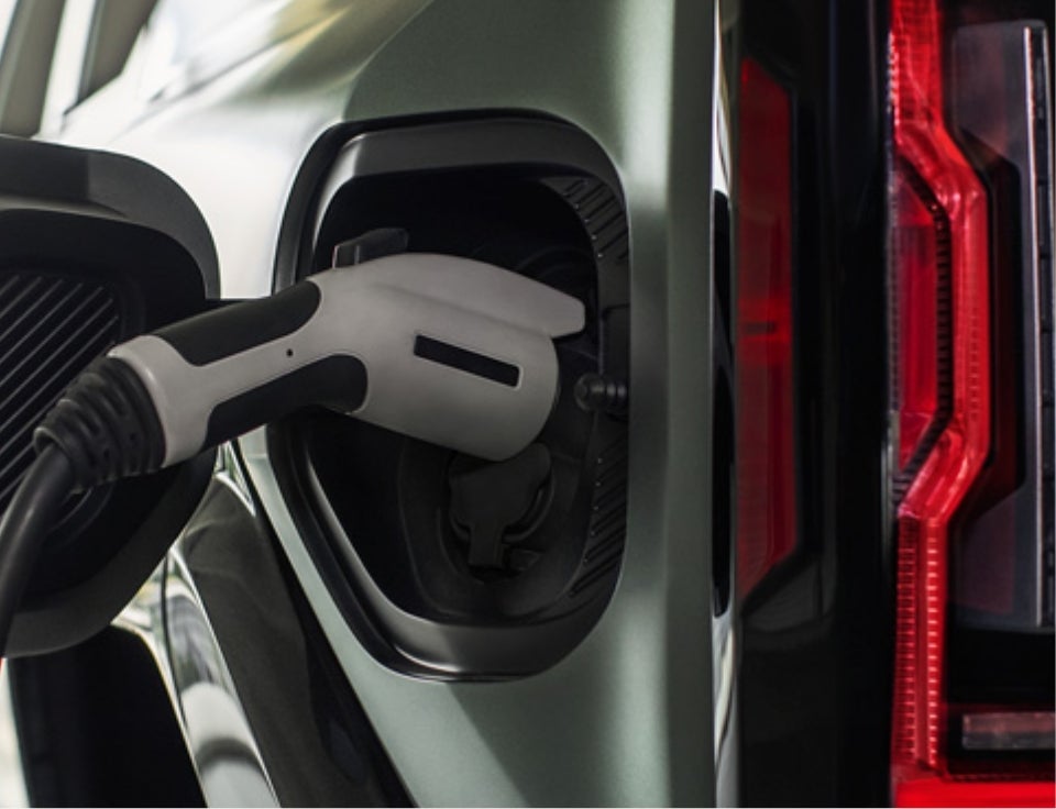 Close up of charging port with charger plugged in on a GMC Hummer EV SUV - Premier GMC in Rittman OH